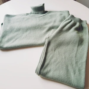 Trendyol set tröja & byxa strl S - Supermysig mintgrön stickad polotröja + byxa från Trendyol. Tröjan har lång ärm, hög polokrage och slits i sidorna för en chill vibe. Perfekt att matcha med de tillhörande stickade byxorna för en komplett look.  Helt skick dock noppror & obehandlade fläckar (se extra bilder)
