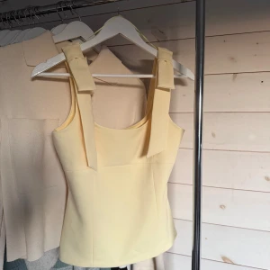 Zara topp - Populär topp från Zara med rosetter på axelbanden, storlek xs och ny med prislapp. 