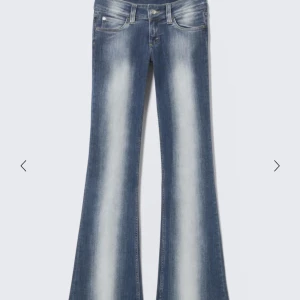 Blå bootcut jeans från Cheap Monday - Säljer ett par blå bootcut jeans från Cheap Monday med snyggt slitna detaljer och ljusa partier framtill. Jeansen har klassisk femficksdesign och är tillverkade i en mix av bomull, polyester och elastan för skön stretch. Perfekta för dig som gillar retrovibbar och markerad siluett.