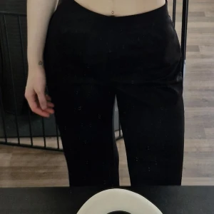 Svarta kostymbyxor från SHEIN - Svarta kostymbyxor från SHEIN i modellen Tall M. Byxorna är högmidjade med en slim passform och har dragkedja i sidan. Snyggt stilrena och passar perfekt till en dressad look. Materialet är mjukt och följsamt, vilket gör dem bekväma att bära hela dagen. Lite smånoppror och tråddragningar finns, men inget som stör