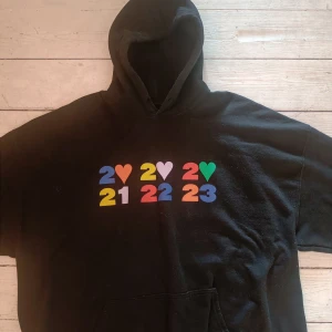 Harry Styles Love On Tour hoodie 2XL - Svart "Thank you" hoodie från Harry Styles Love On Tour med färgglada tryck fram och bak. Materialet är 50% bomull och 50% polyester. 