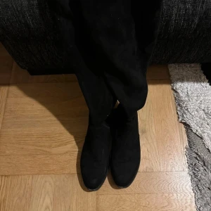 Svarta boots - Snygga svarta stövlar i svart med rund tå och platt sula. Stövlarna går upp över knäet och har dragkedja på insidan för enkel påtagning. Använd ca 2-3 gånger 💗