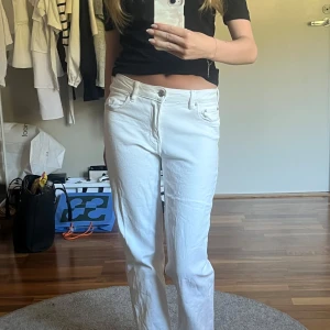 Vita bootcut jeans från Gina  - Säljer ett par vita Gina jeans med bootcut passform och låg midja. Storlek 158. Trendiga fickor med silverknappar bak. Säljer då de tyvärr inte kommer till användning, knappt använda.