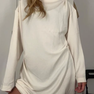 Krämvit långärmad kortklänning - Enkel och stilren krämvit kortklänning med lång ärm och lös passform.  Jätte snygg men tyvärr för stor för mig, är storlek L men skulle tro mer åt M håller beroende på hur lös man vill ha den