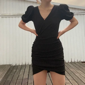 Svart kort omlottklänning med puffärm - Super snygg klänning! Otroligt fin och uppklädd klänning som är så snygg 