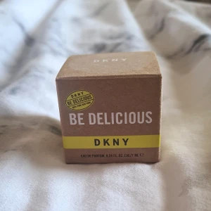 DKNY Be Delicious Eau de Parfum 7ml - Fräsch och fruktig parfym från DKNY, Be Delicious, i en söt miniflaska på 7 ml. Kommer i en brun kartong med vit och gul text. Perfekt att ha med i väskan för en snabb uppfräschning när som helst.