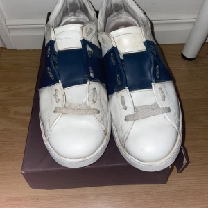 Valentino Garavani Open sneakers vit/blå - Säljer nu mina gamla opens, väl använda som man kan se på sulan men vita färger har hållit väldigt bra ändå storlek 44-45. Även öppen för byten av andra saker  Skriv vid minsta fundering😁