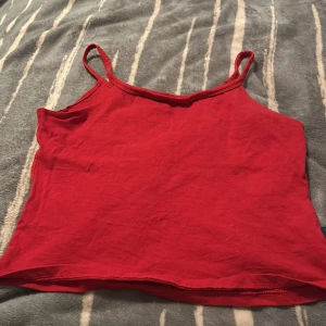 Röd linnetopp från Brooker - En enkel och snygg röd linnetopp från Brooker Jeanswear Collection. Toppen har smala axelband och är croppad i modellen. Tillverkad i mjuk bomull som känns skön mot huden. Perfekt att matcha med jeans eller shorts för en chill look.