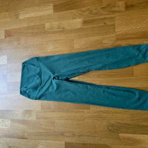 Gröna tränings tights med hög midja - Snygga gröna tränings tights  med hög midja och tight passform. Perfekta för träning eller chill, tillverkade i mjukt och stretchigt syntetmaterial som sitter skönt hela dagen.