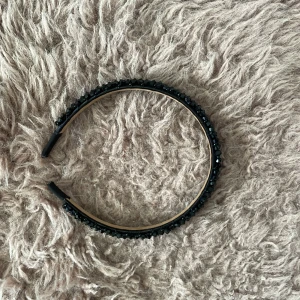 Svart diadem med glittriga pärlor - Snyggt svart diadem täckt med glittriga svarta pärlor som ger en lyxig och trendig känsla. Perfekt accessoar för att lyfta din look och hålla håret på plats. Diademet är bekvämt och passar de flesta huvudstorlekar.