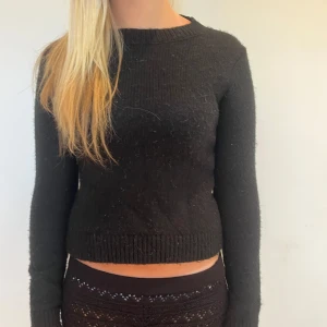 Svart stickad tröja med lång ärm - En svart stickad tröja med rund halsringning och långa ärmar. Tröjan har ribbade muddar vid ärmslut och nederkant. 