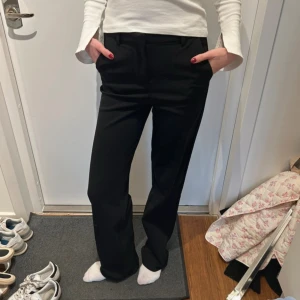 Svarta kostymbyxor med raka ben - Snygga svarta kostymbyxor med klassisk rak passform och midja. Byxorna har hällor för bälte och diskreta fickor fram. Perfekta för en clean och stilren look, passar till både sneakers och boots. Storlek Xs ifrån veromoda skulle säga att det även passar S. 