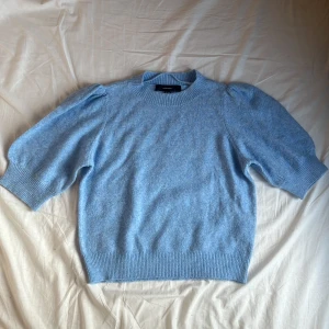 Ljusblå stickad tröja från Vero Moda - Supersöt ljusblå stickad tröja från Vero Moda med puffärmar och ribbade muddar. Tröjan har rund halsringning och kortare ärmar som ger en trendig look. Perfekt att styla med jeans eller kjol för en chill vibe. Nypris 229 kr, pris går att diskutera!! 