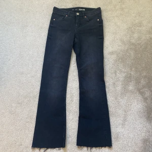 Svarta raka jeans  - Snygga svarta jeans från Bikbok i storlek 34. Jeansen har råa, fransiga benslut och klassisk femficksdesign. Tillverkade i stretchig denim för en bekväm passform och cool look.