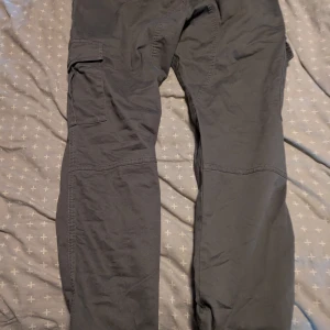 Svarta cargopants med fickor - Säljer som paketpris Säljer ett par svarta cargopants med stora benfickor och raka ben. Byxorna har en clean look och är perfekta för dig som gillar streetwear eller vill ha praktiska byxor med mycket förvaring. Materialet känns slitstarkt och passar till många olika stilar.även ny hoodie allt ifrån jhn sports