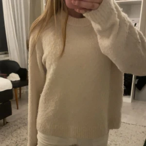 Beige stickad tröja från H&M - Mysig beige stickad tröja från H&M i storlek S. Tröjan har en enkel och clean design med rund halsringning och långa ärmar. Perfekt för lager-på-lager och chill dagar. Passar dig som gillar en basic men ändå snygg vibe.