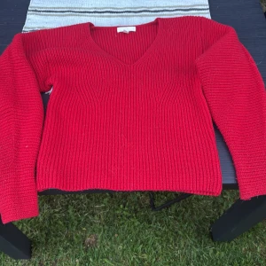 Röd stickad v-ringad tröja - Ribbstickad röd tröja med v-ringning och långa ärmar. Perfekt för dig som gillar en enkel men snygg look. Använd några enstaka gånger.