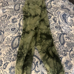 Gröna tie-dye leggings - Snygga gröna leggings med tie-dye mönster i olika nyanser av grönt. De har en tight passform och är perfekta för träning eller en chill vardagslook. Mjukt och stretchigt material som sitter skönt på kroppen.