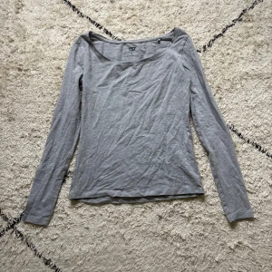 Grå långärmad topp från Lager 157 - En basic grå långärmad topp från Lager 157 i storlek XS. Tillverkad i mjuk bomullsblandning med lite stretch för en skön passform. Enkel och stilren design med rundad halsringning, perfekt att matcha med jeans eller kjol.