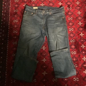 Levi's 517 blå jeans bootcut - Säljer ett par klassiska Levi's 517 jeans i blå denim. Modellen har bootcut-ben och fem fickor, med Levi's Premium-märke och den ikoniska röda Levi's-taggen bak. Jeansen har en snygg tvättad look och är perfekta för dig som gillar retrostil.