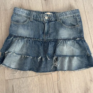 Jeanskjol med volanger från Gina Tricot (SÄNKT PRIS) - Snygg blå jeanskjol från Gina Tricot med volanger. Använd några få gånger