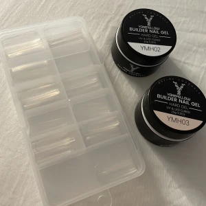 Builder Nail Gel kit med tippar - Säljer ett kit med två burkar Yokefellow Builder Nail Gel i färgerna rosa och klar, perfekt för att bygga naglar med UV/LED-lampa. Medföljer gör även en ask med genomskinliga nageltippar i olika storlekar. Allt du behöver för snygga och hållbara naglar hemma.