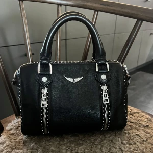 Zadig & Voltaire väska - En fin Zadig väska i modell ”sunny graine XS” med måtten 24x15x12. Använd med lite skav på öglor och crossbody spännen som visas på bilderna. Prislapparna finns kvar och medföljer. Fråga gärna om fler bilder önskas.