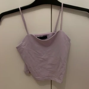 Ljuslila linnetopp  - Säljer en ljuslila linnetopp från XOXO friends med tunna axelband och enkel, stilren design. Toppen är ärmlös och har en mjuk, slät yta som känns skön mot huden. 💜