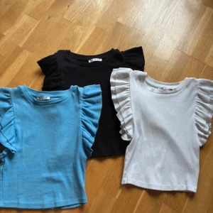 Linne med volang vid axeln från Zara - Tre super söta linnen från Zara, i färgerna blå, svart och vit.  Topparna har volanger längs axlarna vilket skapar en jätte söt look. Använda fåtal gånger.🥰Erbjudande om nytt pris går💗