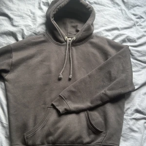 Svart hoodie från BikBok med huva - Svart hoodie från BikBok i storlek S. Klassisk modell med huva, snörning och stor magficka framtill. Mjuk insida och ribbade muddar vid ärmslut och nederkant. Perfekt för chill dagar eller när du vill ha en enkel och stilren look.