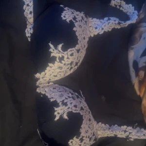 Mörkblå Intimissimi spets-bh med vita detaljer - Snygg svart bh med vita spetsdetaljer och blommigt mönster. Kuporna är vadderade och axelbanden är dekorerade med spets för en extra fin look. Perfekt för dig som gillar romantiska och feminina underkläder.