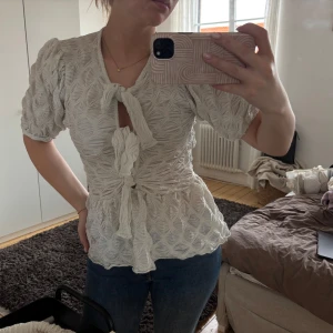 vit/Beige blus med knyt från NA-KD - Supersöt beige blus från NA-KD med puffärmar och snygg struktur i tyget. 🤍🤍🤍