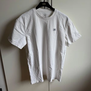 Vit t-shirt från Lee - Säljer en klassisk vit t-shirt från Lee i storlek M. T-shirten har en avslappnad passform och är tillverkad i mjukt bomullsmaterial. Perfekt för en enkel och stilren look. Använd cirka 2 gånger. 