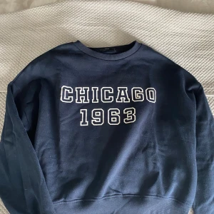 Mörkblå sweatshirt med tryck - Säljer en mörkblå sweatshirt från Only märket Pigalle med vit text på framsidan. Tröjan har en klassisk rund halsringning och är perfekt för en avslappnad stil. 