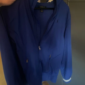 Blå vindjacka från Ralph Lauren - Säljer en as snygg blå windbreaker från Ralph Lauren. Jackan är knappt använd och är i ett mycket bra skick, perfekt väder för användning just nu, bara att höra av er med minsta fundering.. 😁👍🏼