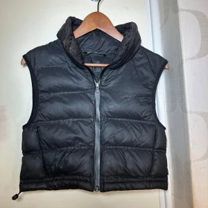 Svart croppad dunväst från ZARA - Snygg svart croppad dunväst från Zara med dragkedja framtill!