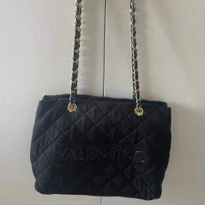 Valentino Väska - En väska från VALENTINO. Har slitningar på bandet (se bild 3), därav priset. Nypris 1469kr, men finns inte längre att köpa. Köparen står för frakten. Pris kan diskuteras vid snabb affär! 