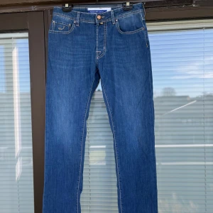 Jacob Cohen BARD W32 - Snygga blå jeans från Jacob Cohen  med knappgylf. Model BARD i storlek W32. Perfekta för våren som är här. Är du sugen på några riktigt feta brallor är det bara att skriva☀️🍾!