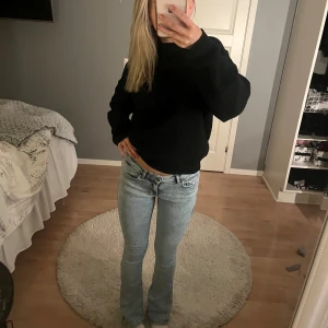 Ljusblå bootcut jeans - Säljer ett par ljusblå bootcut jeans med låg midja. Jeansen har en klassisk femficksdesign och en snygg tvätt som ger en avslappnad look. Perfekta för en trendig stil!