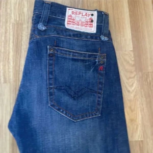 Blå jeans från Replay - Snygga blå jeans från Replay med klassisk femficksdesign och en bekväm passform. Jeansen har en lätt tvättad look och är perfekta för en avslappnad stil. Märkeslogga på bakfickan och en tydlig etikett vid linningen.
