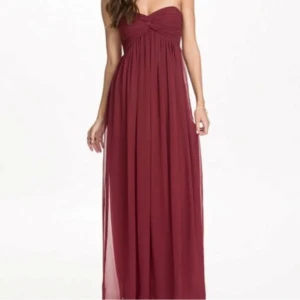 Vinröd axelbandslös långklänning - Fin vinröd långklänning med axelbandslös design. Perfekt för bal🩷 från Nelly och är oanvänd med prislappen kvar! Säljer för att den är för stor för mig.