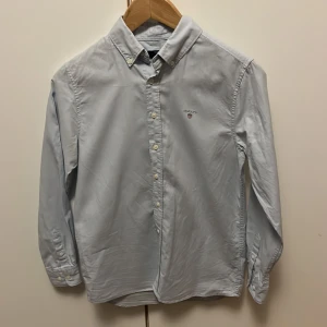 Ljusblå skjorta från GANT - Säljer en stilren ljusblå skjorta från GANT med button down krage och knappar framtill. Perfekt för en snygg och avslappnad look. Använd 3 gånger och har därför perfekt skick.
