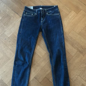 Dondup jeans - Snygga mörkblå jeansbyxor med kontrasterande sömmar och klassisk femficksdesign. Byxorna har en rak passform och är perfekta för en avslappnad stil. De har en knapp och dragkedja framtill.
