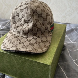 Beige keps från Gucci - beige keps från Gucci med det klassiska GG-mönstret. Helt ny knappt använd, inga skador inga fel på den. Pris kan diskuteras, den är äkta all behörighet finns till den. Byten kan kanske tas emot det kan diskuteras, mer info dm.