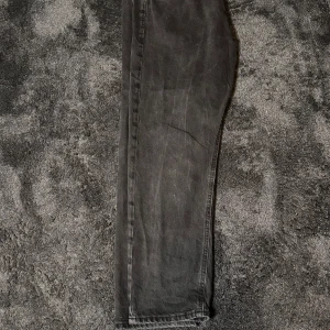  Jack & Jones jeans - Snygga grå jeans från Jack & Jones med en klassisk design. De har en knappgylf och bälteshällor, vilket gör dem perfekta för en avslappnad stil. Jeansen har en diskret tvättad look som ger dem en trendig touch. Byxorna är storlek: 33/30.