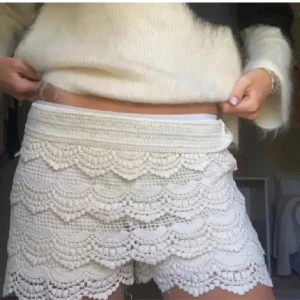 Vita virkade shorts - Snygga vita virkade shorts med ett vackert mönster och elastisk midja. Perfekta för en somrig look med sin luftiga design och dekorativa detaljer.