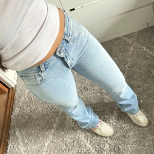 Ljusblå bootcut jeans - Snygga ljusblå bootcut jeans med låg midja. Perfekta för en avslappnad stil. Klassisk femficksdesign och dragkedja med knapp framtill. För referens är jag ca 164 cm lång💗