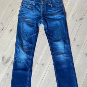 Nudie Jeans Grim Tim - 32/34 egentligen men upplagda så de är lite kortare i längden. Lagade hos Nudie jeans i somras men en lagning har släppt pyttelite dock inget farligt. Midjemått 40,5cm innerbenslängd 75cm