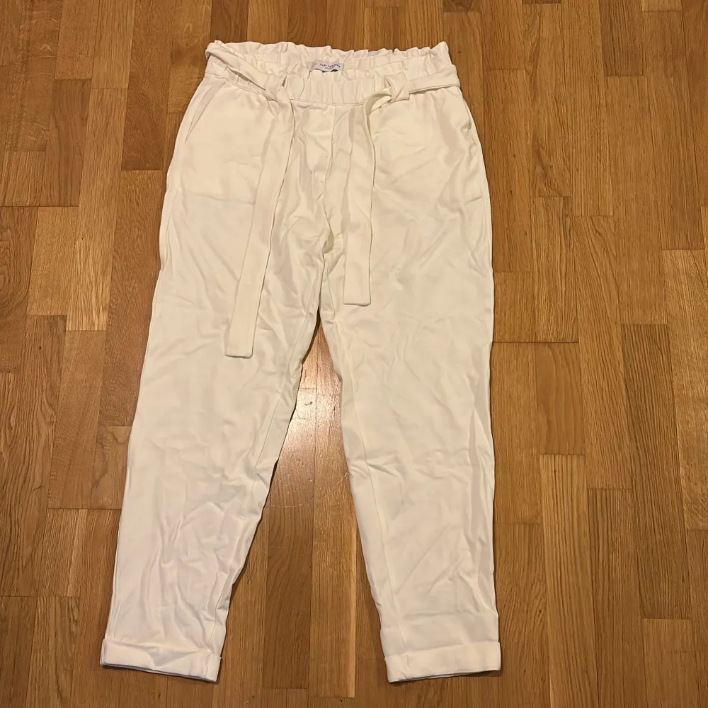 Snygga vita byxor från Ifepi Heritage Collection med risår i midjan och knytband. Byxorna har en avslappnad passform och är perfekta för en stilren look. De är tillverkade i ett mjukt material som ger en bekväm känsla hela dagen. Helt oanvända!. Farkut & Housut.