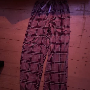 Rutig byxa med snörning - Säljer ett par bekväma byxor med rutig design och snörning i midjan. Perfekta för en avslappnad stil.